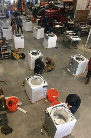 photo d'un atelier où plusieurs laveuses sont en train d'être transformés en essoreuses à mesclun